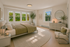Elegant bedroom with large windows, contemporary decor, and cozy natural lighting, offering a serene retreat.