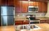 Modern kitchen with stainless steel appliances and granite countertops.
