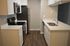 Modern kitchen with sleek appliances, white cabinetry, and elegant hardwood flooring.