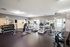 Modern fitness center with state-of-the-art treadmills, weightlifting equipment, and mirrors reflecting natural light.
