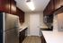Modern kitchen with sleek stainless steel appliances, elegant dark wood cabinets, and a bright, inviting atmosphere.
