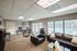 Inviting communal lounge space with plush leather seating, elegant decor, and large windows overlooking a serene pool area.