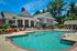 Luxurious apartment complex with a stunning outdoor pool, surrounded by elegant architecture and lush gardens.