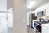 Bright and modern kitchen with stainless steel appliances, sleek countertops, and ample natural light flowing through the adjacent sliding glass door.