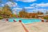 Inviting outdoor pool area surrounded by lush greenery and lounge chairs, perfect for relaxation and leisure.