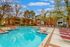Inviting apartment complex with a sparkling outdoor pool, surrounded by comfortable lounge chairs and lush greenery, perfect for relaxation and leisure.