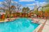 Inviting outdoor pool area surrounded by modern apartment buildings and lush greenery, perfect for relaxation.