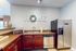 Charming kitchen featuring stainless steel appliances, rich wooden cabinetry, and bright decor with a welcoming 'Home' sign.
