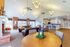 Spacious and inviting living area with high ceilings, elegant chandeliers, and a cozy fireplace. Features plush leather sofas, a stylish sitting area, and a modern bar, perfect for entertaining.