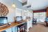 Bright and inviting office space with elegant decor, featuring multiple workstations, stylish lighting, and a large window offering natural light.