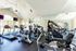 Bright and modern fitness center equipped with treadmills, stationary bikes, and large windows for natural light.