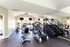 Bright and airy fitness center equipped with modern cardio machines and mirrored walls, offering a refreshing workout experience.