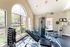 Bright and modern gym with large arched windows, state-of-the-art fitness equipment, and serene garden view.