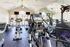 Bright and modern fitness center with state-of-the-art equipment, large mirrors, and expansive windows allowing natural light.