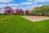Picturesque outdoor volleyball court surrounded by vibrant green grass and colorful trees, perfect for recreation and relaxation.