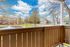 Charming apartment balcony view with a serene fountain pond, lush greenery, and picturesque blue sky.