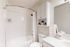 Chic bathroom with elegant white tiles, modern vanity, and tasteful decor, perfect for relaxation.