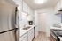 Modern kitchen with sleek stainless steel fridge, white cabinetry, and elegant countertops for a stylish culinary experience.