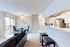 Bright and modern open-plan living space featuring sleek kitchen, cozy dining area, and comfortable seating with natural light.