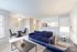 Bright and modern living space with plush navy sofa, open dining area, and sleek kitchen layout.
