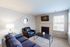 Bright and inviting living room with contemporary furniture, sleek fireplace, and ample natural light from wide windows.