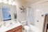 Inviting bathroom with modern fixtures, elegant vanity, and a decorative star accent, offering a glimpse into a cozy bedroom.