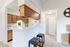Inviting kitchen space with modern wooden cabinetry, cozy breakfast bar, and stylish bar stools.