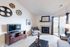 Chic living room with modern decor, featuring a cozy fireplace, sleek TV stand, and balcony access through sliding glass doors.