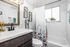 Charming bathroom with stylish floral shower curtain, elegant dark wood vanity, and vibrant bird-themed wall art, creating a refreshing and inviting space.