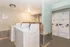 Bright, welcoming laundry room with modern washers and dryers, accented by rustic paneling and contemporary lighting.