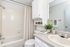 Elegant and modern bathroom featuring a sleek vanity, built-in storage, and stylish decor.