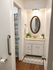 Inviting bathroom with decorative oval mirror, elegant vanity, and tranquil shower area featuring modern fixtures.