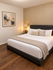 Cozy bedroom with plush bedding, warm lighting, and elegant decor creating a serene atmosphere.