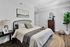 Bright, modern bedroom with cozy bed, stylish decor, and greenery.