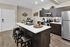 Elegant kitchen with modern appliances, sleek cabinetry, and a central island with bar seating.