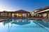 Beautiful apartment complex pool area with lounge chairs and umbrellas at sunset.