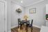 Stylish dining nook with a modern table set for two, accented with a decorative plant arrangement and wall decor.