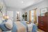 Bright and airy bedroom featuring a plush bed, elegant furniture, and natural light pouring through curtains.