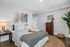 Bright modern bedroom with cozy bedding, a stylish dresser and elegant decor.