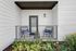 Inviting patio with cozy seating and decorative pillows, surrounded by lush greenery.