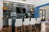 Stylish coffee bar with blue tiled backsplash, tufted bar stools, and modern amenities.