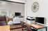 Elegant home office setup with a view into a stylish living room featuring modern decor.