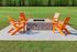 Outdoor fire pit with four vibrant orange chairs on a grass lawn, surrounded by lush greenery.