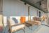 Elegant outdoor lounge with comfortable seating, wooden tables, and a cozy ambiance, perfect for relaxation.
