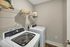 Modern laundry room featuring sleek washer and dryer, complemented by a spacious wire shelf perfect for storage.