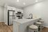 Modern kitchen with sleek stainless steel appliances, elegant white cabinetry, and a stylish island with bar stools, perfect for entertaining.