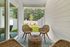 Inviting outdoor patio with stylish wicker chairs and a scenic garden view, offering a serene retreat.