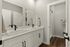 Elegant bathroom with dual sinks, modern fixtures, and a spacious countertop, complemented by sleek cabinetry and a stylish walk-in shower.