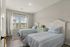 Bright and inviting twin bedroom with stylish decor, featuring large windows that offer scenic views and natural light.