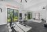 Bright home gym with modern fitness equipment, featuring large windows with serene outdoor views.